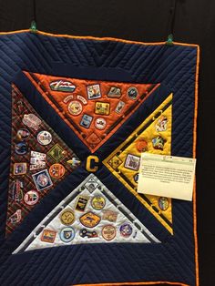 a quilted wall hanging with patches and magnets on it's center piece