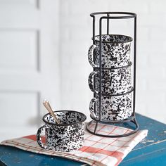 two mugs sitting on top of a blue table next to a red and white checkered napkin