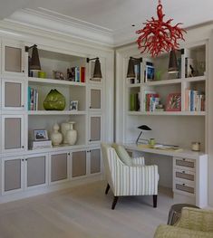 a living room filled with lots of white furniture and bookshelves covered in shelves