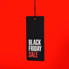 a black friday sale tag hanging on a red wall