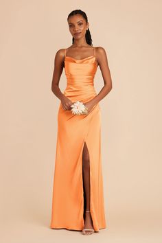 a woman in an orange dress posing for the camera