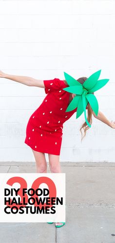 a girl in a red dress is holding up a green poinsettia