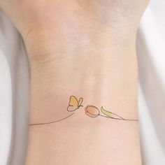 a small tattoo on the wrist of a woman's left arm with two butterflies