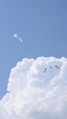 two kites are flying in the sky above some clouds