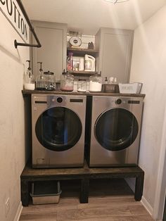 two washers sitting next to each other in a room with a sign on the wall