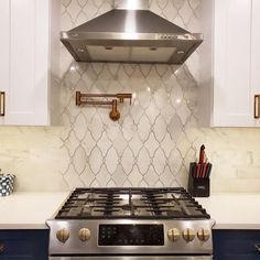 a stove top oven sitting inside of a kitchen next to white cupboards and counter tops