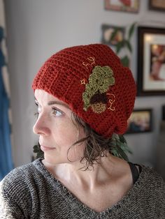 a woman wearing a red knitted hat with flowers on it