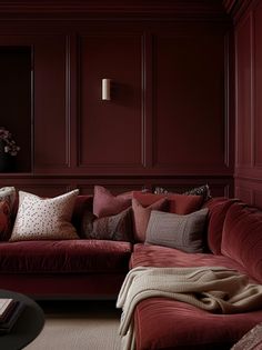 a living room filled with red couches and pillows