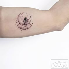 a person's arm with a tattoo on it that has an astronaut sitting on the moon