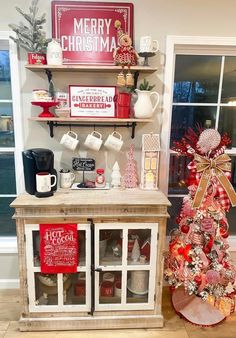 a small christmas tree sitting next to a shelf filled with coffee cups and mugs