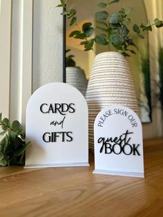 two cards and gifts sitting on top of a table next to a potted plant