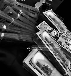 black and white photograph of stacks of $ 100 bills on top of eachother