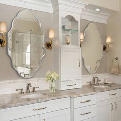 a bathroom with double sinks and two mirrors on the wall next to eachother