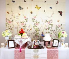 the table is decorated with flowers, pictures and cake on it's tablescloth