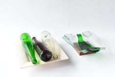 three empty glass bottles sitting on top of a white plate