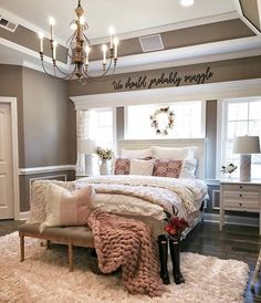 a bedroom with a large bed, chandelier and white rugs on the floor