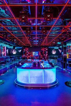 the inside of a nightclub with blue and red lights, neons and video screens