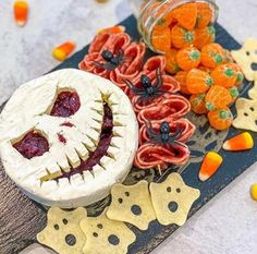 an assortment of halloween treats are arranged on a table with candy and candies in the background