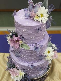 there is a purple cake with flowers on it