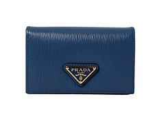 This vibrant blue Prada card holder is an effortlessly chic way to store credit cards, business cards, coins, and small objects. The wallet's conveniently small size makes it easy to keep in your purse or pocket. Three card slots and a main pocket mean organizing is a breeze.     Model: 1MC122  Cobalto blue leather  Gold-tone hardware  Snap closure  Card holder/wallet  Signature Prada Triangle logo   Measurements: 4.5" x 1.5" x 2.5" (LWH)  Includes authenticity cards and Prada box   Made in Ital Modern Wallets With Logo Plaque For Everyday, Formal Blue Bags With Card Slots, Classic Blue Wallets With Card Slots, Classic Blue Wallet With Card Slots, Blue Classic Card Holder For Daily Use, Classic Blue Card Holder For Daily Use, Designer Blue Bags With Card Slots, Blue Designer Bags With Card Slots, Blue Elegant Card Holder With Rfid Blocking