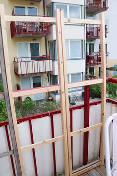 an apartment building with red balconies next to it's windows and balcony