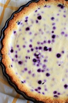 a pie with blueberries in it sitting on a plate