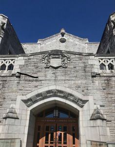 the entrance to an old stone building with a clock on it's front door