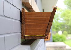 a piece of wood is attached to the side of a building with an orange cord