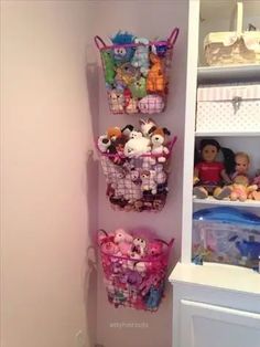 there is a shelf with stuffed animals and toys in baskets on the wall next to it