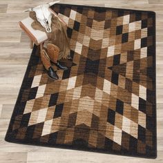 a brown and black area rug sitting on top of a wooden floor next to a cow skull