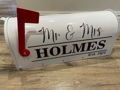 a white mailbox with the word mr and mrs written on it, sitting on a wooden floor