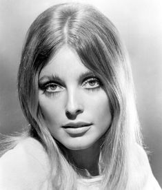 an old black and white photo of a woman with long blonde hair wearing eyeliners