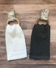 two baby swaddles are sitting on a wooden floor next to each other, one is black and the other is white