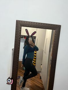 a woman taking a selfie in front of a mirror with bunny ears on her head