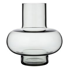 a clear glass vase sitting on top of a white table next to a black base