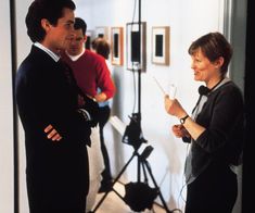 two men and a woman standing in front of a camera