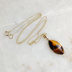 "You can choose your own gem in my store. Let me know if you would like to see options Gemstone: Brown YellowTiger Eye Gold Purity : Guaranteed 14kt pure GOLD Gem weight 9.60 carats Gem shape: Marquis Cabachon shape Gold weight: 0.56 grame Total weight: 2.48 grame The Gemstone in this pendant is ethically sourced and is exploitation free. Brown Yellow Tiger Eye is a beautiful Gemstone of patterns like no other Gemstone. Please note that the pendant is made with absolutely pure 14kt Gold. Pendant Yellow Gold Marquise Necklace For Gift, Hallmarked Yellow Gold Gemstones For Gift, 14k Yellow Gold Gemstones For Gift, Gold Pendant Gemstones As A Gift, Gold Pendant Gemstones For Gift, 14k Gold Gemstones With Bezel Setting For Gift, 14k Gold Marquise Necklace Perfect For Gifts, Yellow Gold Cabochon Teardrop Pendant Necklace, 14k Gold Cabochon Jewelry As Gift