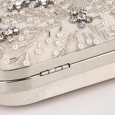 Searching for the perfect accessory to elevate your wedding dress or evening attire? The Crystal Elegance Pearl Beaded Clutch is a stunning choice that exudes romantic sophistication and poetic charm. An elegant statement clutch featuring a delicate beaded design with white pearls and crystals, complemented by silver hardware and a smooth satin back. Its crisp, feminine style makes it a standout piece for any big days and special occasion. Why We Love It... We adore the intricate beaded floral d Embellished Cream Evening Bag For Party, Silver Embellished Evening Bag For Wedding, Elegant Beaded Bridal Accessories For Party, Cream Evening Bag With Pearl Embroidery For Wedding, Chic Beaded Evening Bag For Wedding, Silver Embellished Bridal Accessories For Evening, Elegant Beaded Bridal Accessories For Evening, Elegant Evening Bag With Pearl Embroidery For Wedding, Elegant Embellished Evening Bag For Wedding