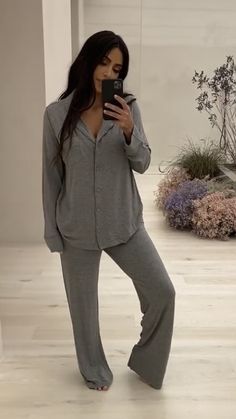 a woman taking a selfie while wearing pajamas and holding a cell phone in her hand