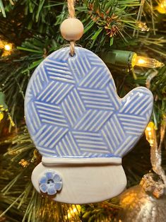 a ceramic ornament hanging from a christmas tree