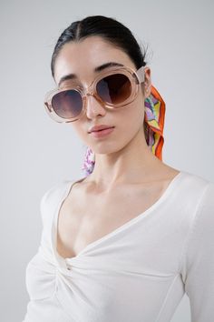 Embrace a timeless aesthetic with our Oversized Circular Sunglasses in Translucent White. Crafted from 100% polycarbonate, these sunglasses offer a durable and lightweight design that ensures comfort throughout the day. The translucent white frames add a modern twist to the classic oversized circular shape, making them a chic accessory for any outfit.  The model is wearing size U, which is a universal fit, guaranteeing that these stylish sunglasses will suit various face shapes and sizes. Perfect for adding a touch of sophistication to your look, these sunglasses are ideal for sunny days at the beach or casual city outings. Circular Sunglasses, Tan Scarf, White Frames, Timeless Aesthetic, Photography Gifts, Scarf Headband, Stylish Sunglasses, Chic Accessories, Romper Pants