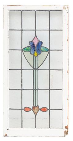 an old stained glass window with flowers in the center and two leaves on each side