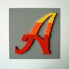 an image of a letter made out of legos on a white surface with the letter k in red, yellow and orange