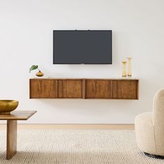 a flat screen tv mounted to the side of a wooden cabinet in a living room