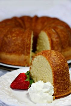 a pound cake on a plate with whipped cream and strawberries