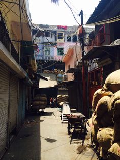 an alley way with lots of bags on the ground and buildings in the background,