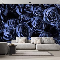 a living room with blue roses on the wall and couches in front of it