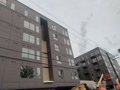 a construction truck is parked in front of an apartment building that has been under construction