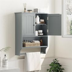 a bathroom with a gray cabinet and white towels