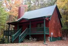 a log cabin in the woods with stairs leading up to it's second floor